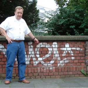 Jürgen Lüdemann vor Graffitis